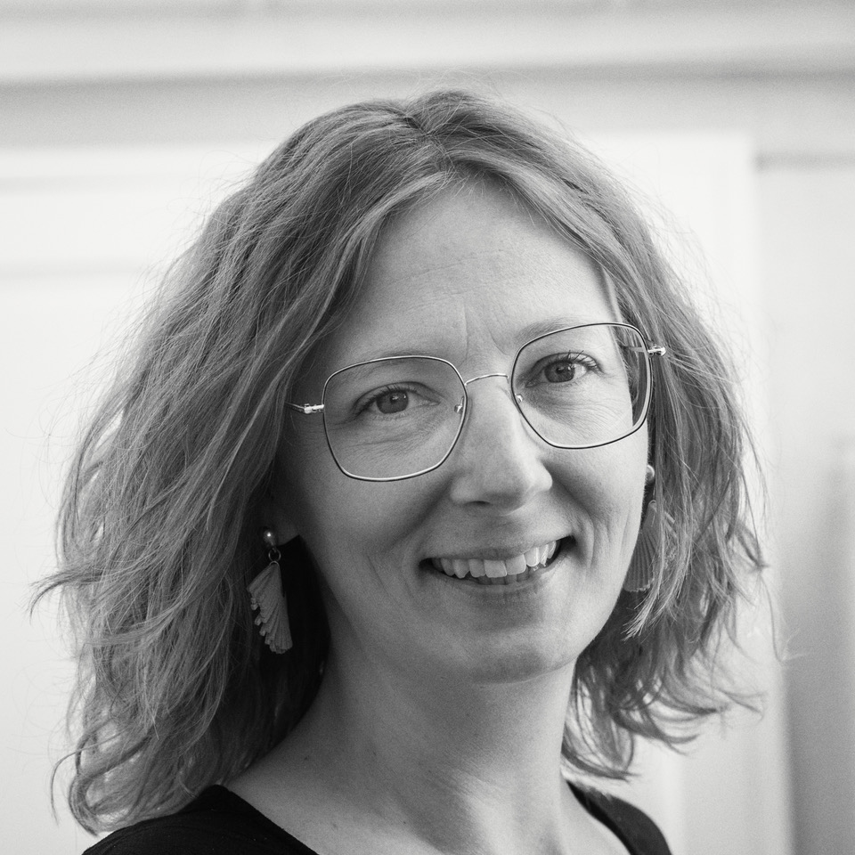 a woman in a tan jacket and tan pants